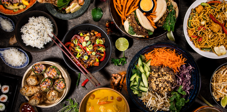 Asian food background with various ingredients on rustic stone background, top view.